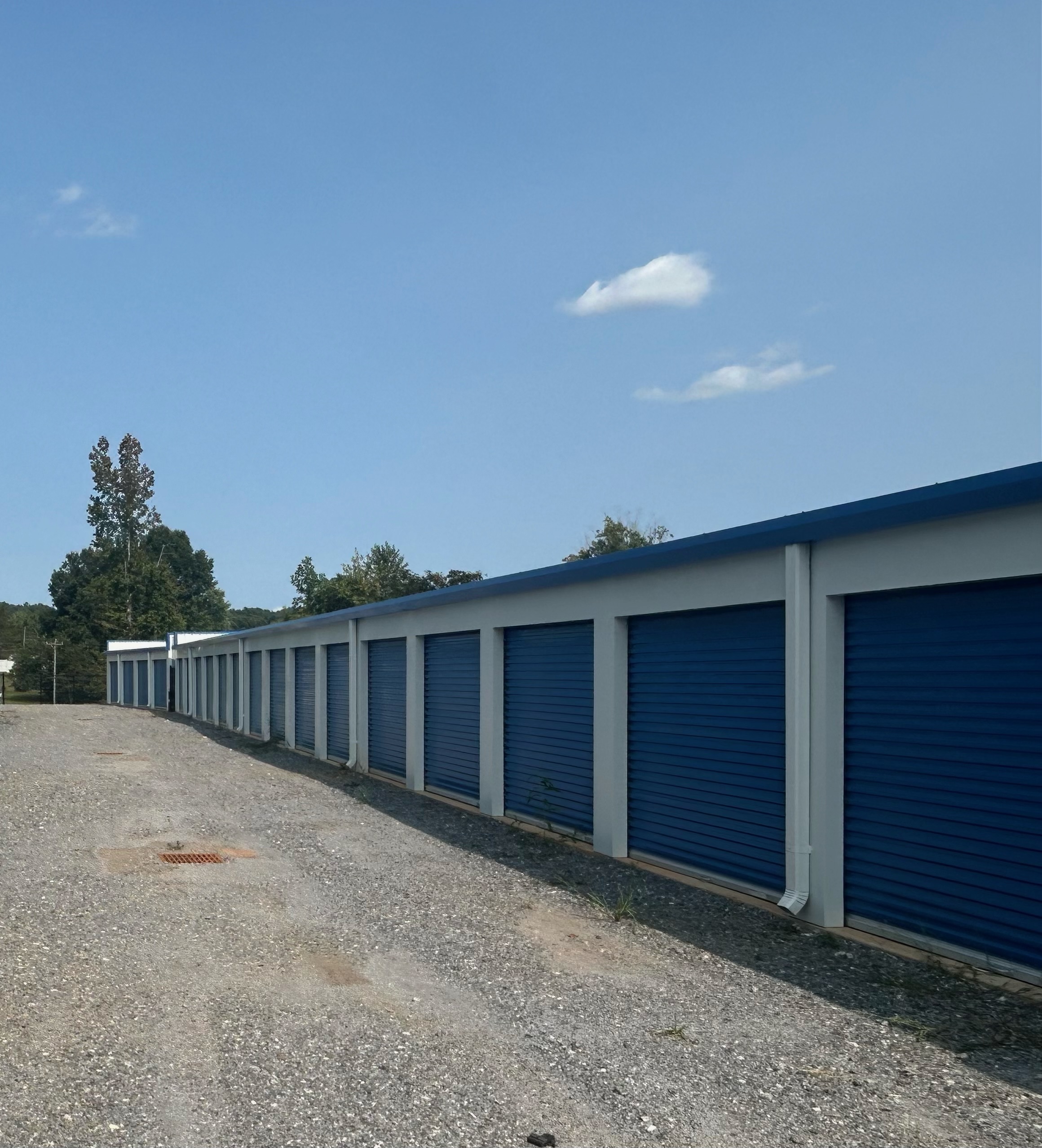 A long row of clean blue drive-up storage units at Storage Solutions of Lenoir