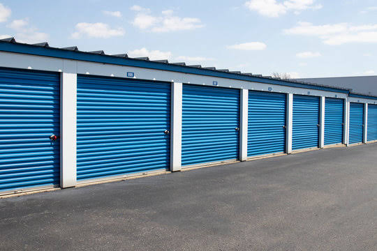 Close-up of blue storage unit doors along a paved drive